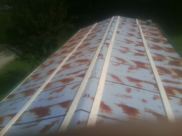 Rusted metal roof panels with new wood purlins before replacement — Storm Damage Roof Repair in Strongsville by Roofing Brothers