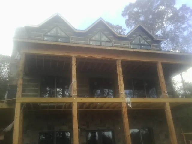 Dormers and porch framing on a large log home under construction — Roof Coating work by our crew in Strongsville
