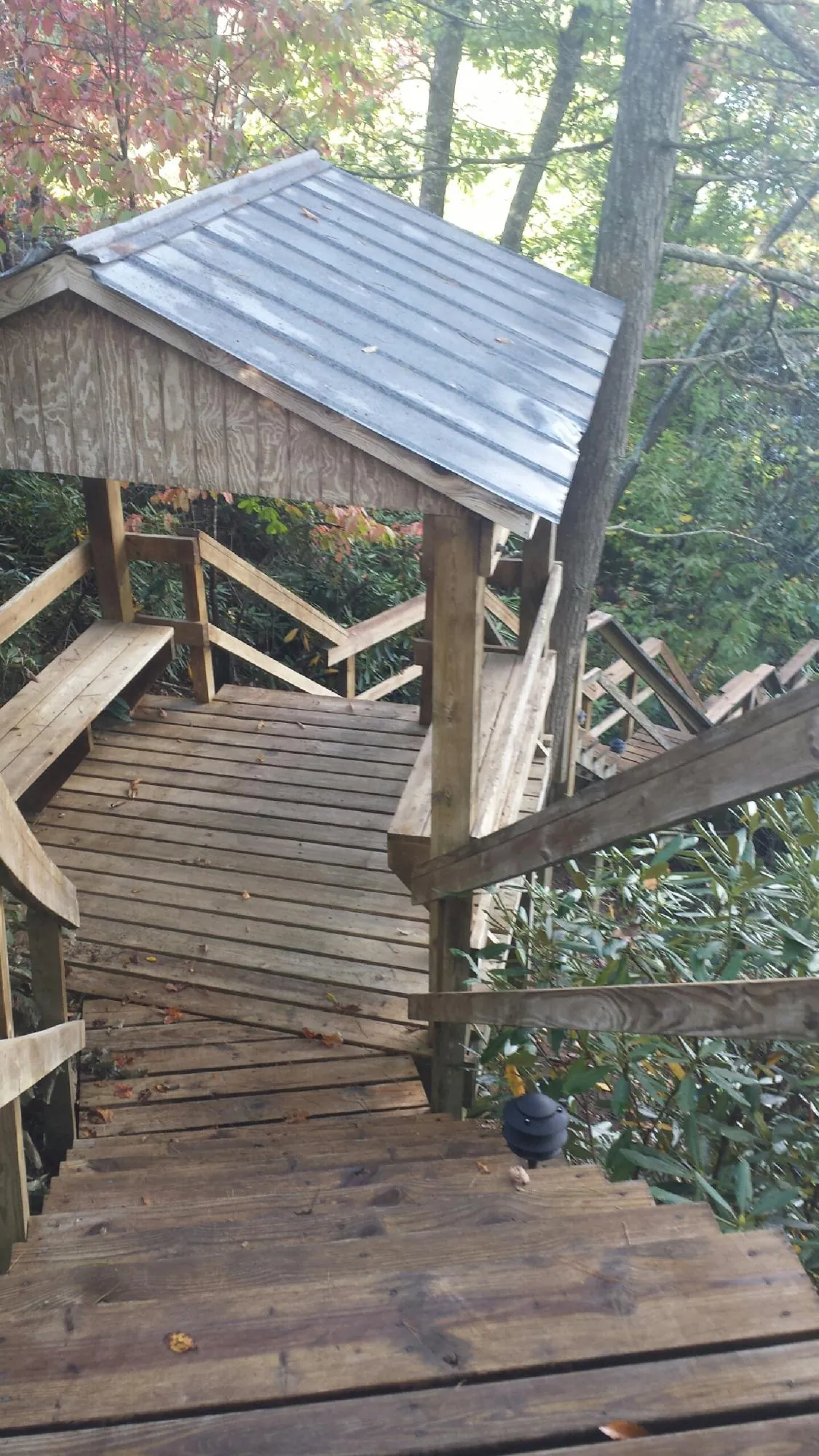 Metal roofed shelter over wooden steps on a wooded walkway — Skylight Repair & Installation work by our crew in Strongsville