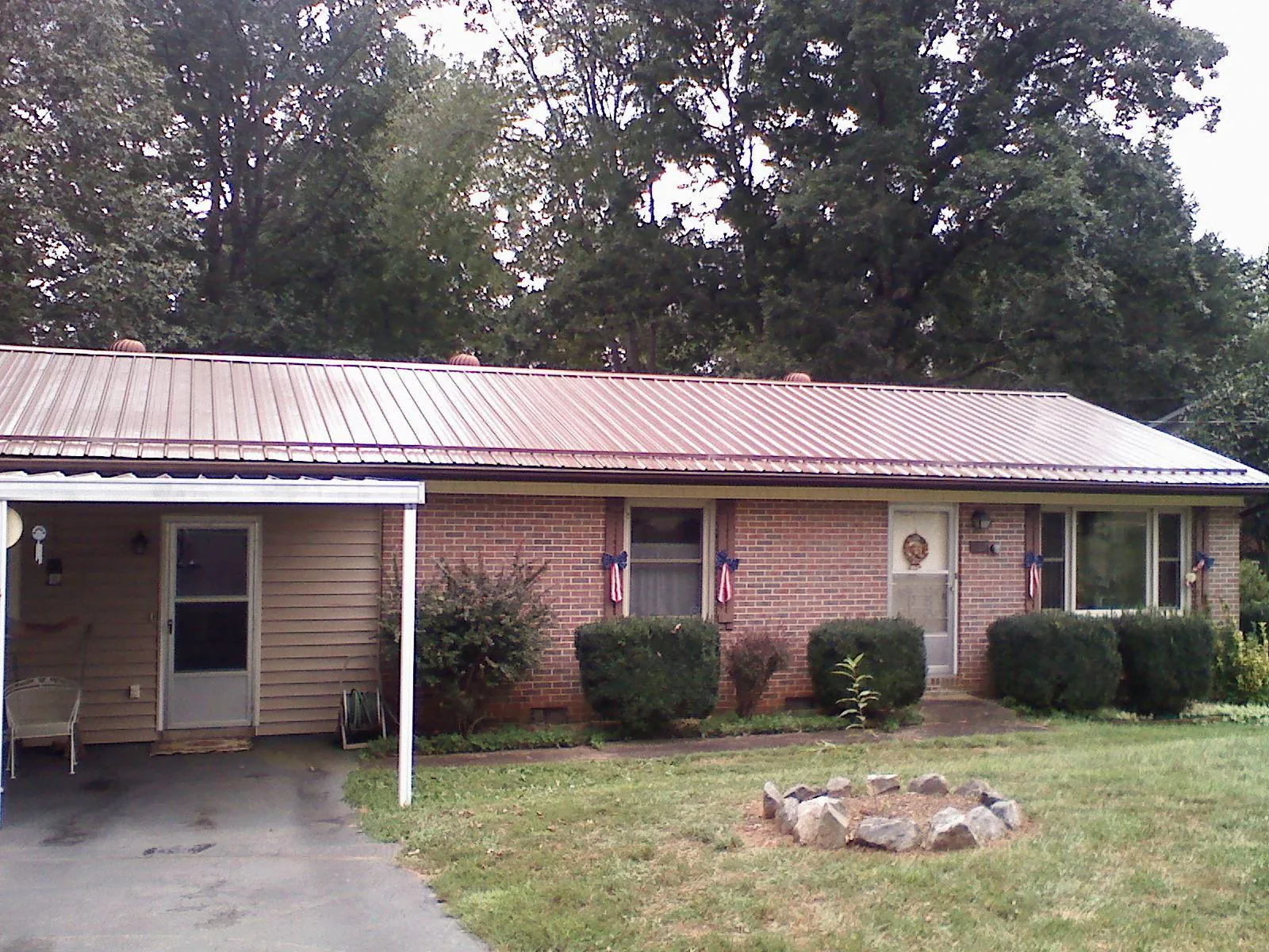 Bronze metal roof and carport on a brick ranch home — Roof Repair work by our crew in Strongsville
